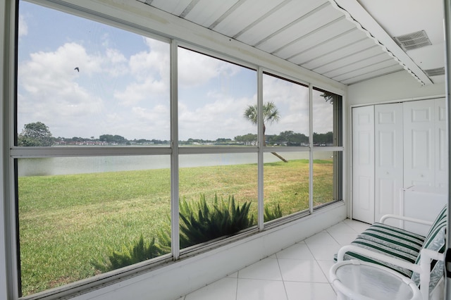 sunroom / solarium featuring beam ceiling and a water view