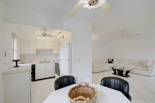 interior space featuring ceiling fan, white cabinets, white refrigerator, light tile patterned flooring, and sink