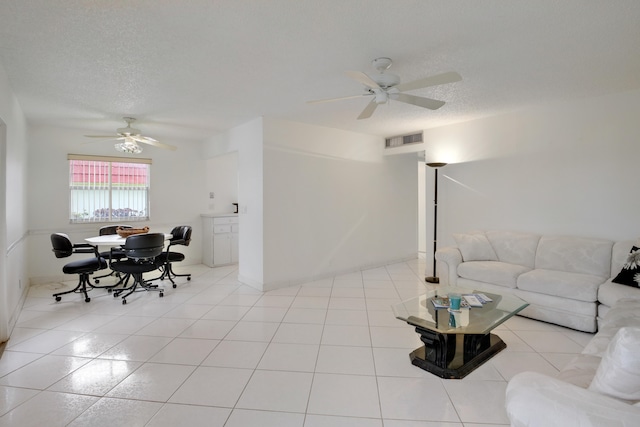 tiled living room featuring ceiling fan and a textured ceiling