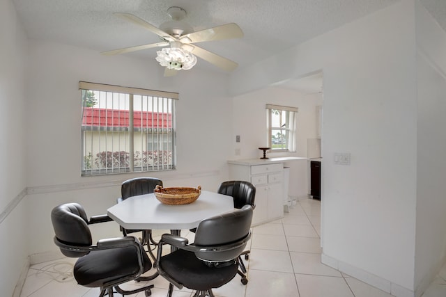 dining space with light tile patterned flooring, plenty of natural light, and a textured ceiling