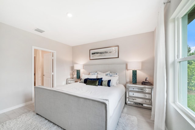 bedroom with light hardwood / wood-style flooring and multiple windows