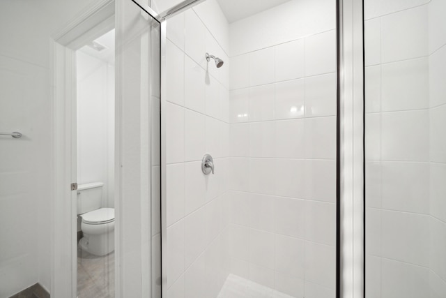 bathroom with toilet and an enclosed shower