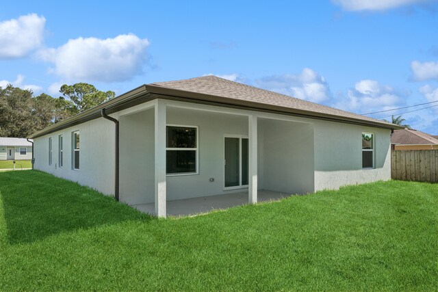 rear view of house with a patio area and a lawn