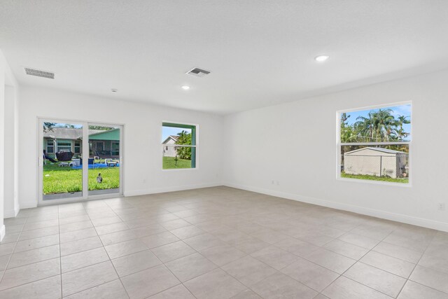 unfurnished room with a healthy amount of sunlight and light tile patterned flooring