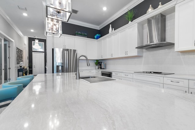 kitchen with wall chimney exhaust hood, black electric stovetop, stainless steel fridge, and ornamental molding