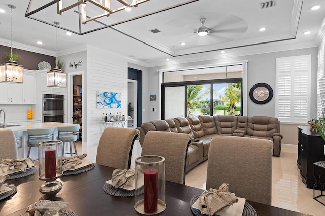 dining area with ceiling fan, visible vents, and a raised ceiling