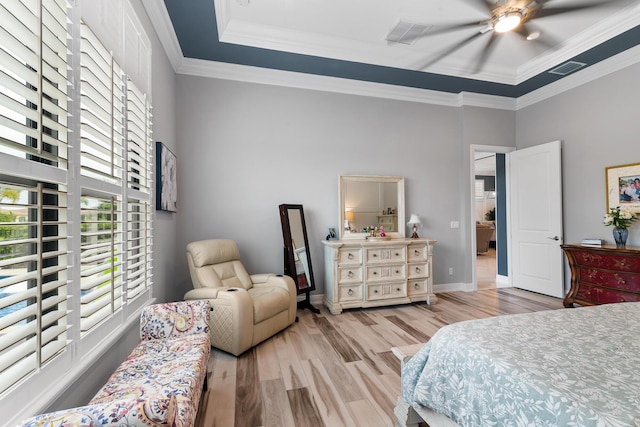 bedroom with crown molding, visible vents, a ceiling fan, wood finished floors, and baseboards