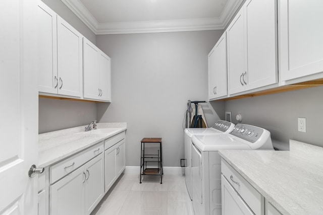 washroom with separate washer and dryer, a sink, baseboards, cabinet space, and crown molding