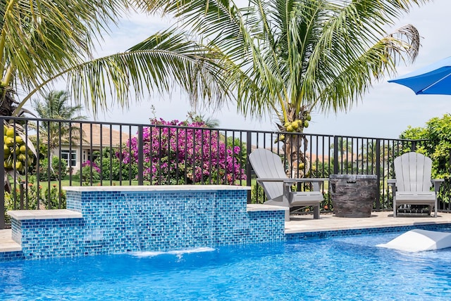 view of swimming pool featuring fence