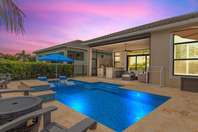 view of swimming pool featuring a fenced in pool, a patio, outdoor dry bar, an outdoor hangout area, and ceiling fan