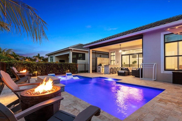 pool at dusk featuring a fenced in pool, an outdoor living space with a fire pit, a patio, area for grilling, and fence