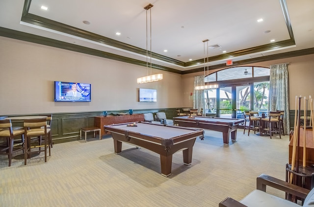 recreation room with light carpet, wainscoting, pool table, a tray ceiling, and crown molding