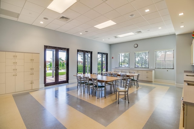 dining space with light floors, baseboards, visible vents, and french doors