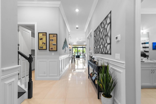 corridor featuring wainscoting, stairway, a decorative wall, and light tile patterned flooring