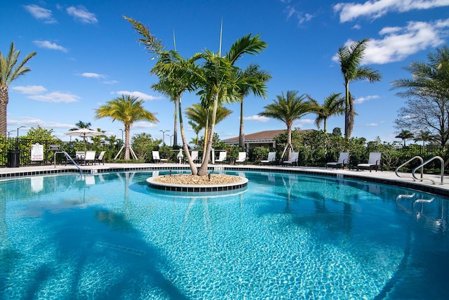 community pool featuring a patio and fence