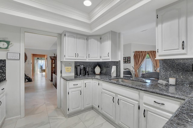 kitchen featuring decorative backsplash, white cabinetry, ornamental molding, and sink