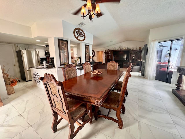 dining room with a textured ceiling, ceiling fan, and vaulted ceiling