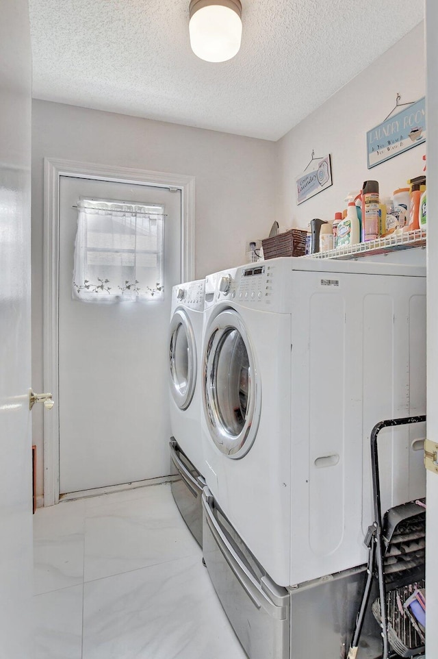 laundry room featuring washing machine and dryer and a textured ceiling