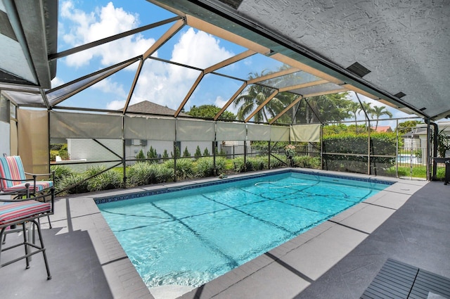 view of swimming pool with a patio and glass enclosure