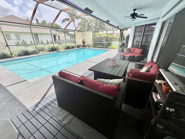 view of swimming pool featuring a lanai, ceiling fan, a patio, and an outdoor living space