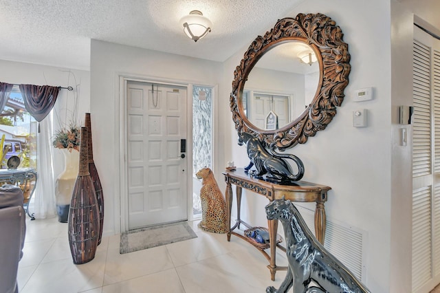 entryway featuring light tile patterned floors and a textured ceiling