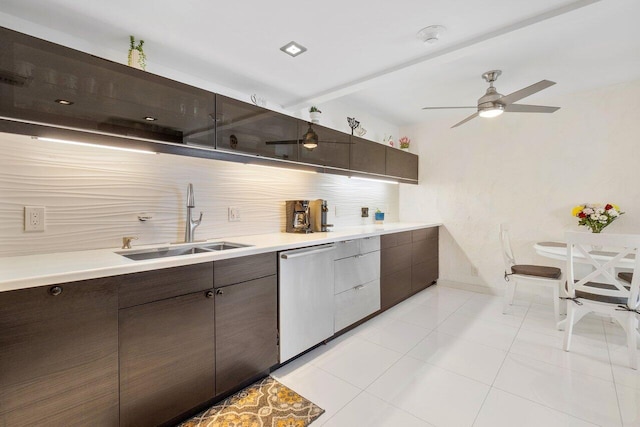 kitchen featuring dishwasher, light tile patterned floors, decorative backsplash, dark brown cabinets, and sink