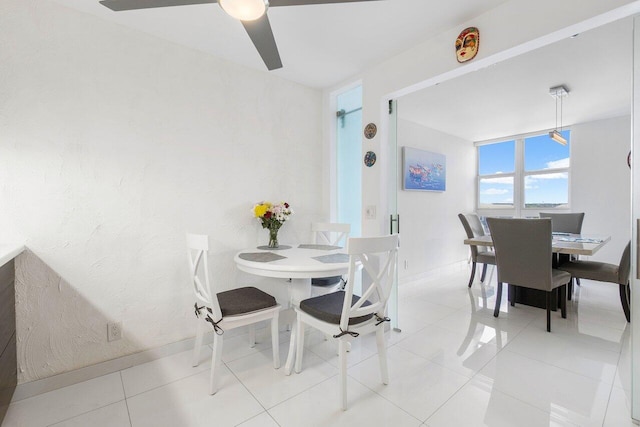 tiled dining space featuring ceiling fan