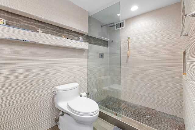 bathroom featuring toilet and tiled shower