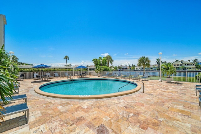 view of pool with a patio and a water view