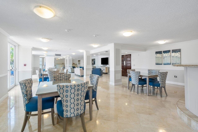 dining area featuring a textured ceiling and ornamental molding