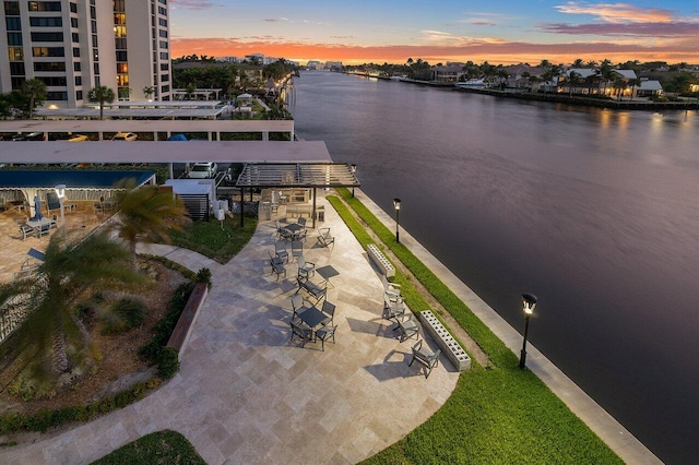 aerial view at dusk featuring a water view