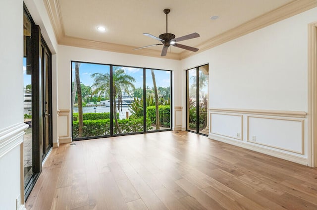 spare room featuring crown molding, ceiling fan, and light hardwood / wood-style floors