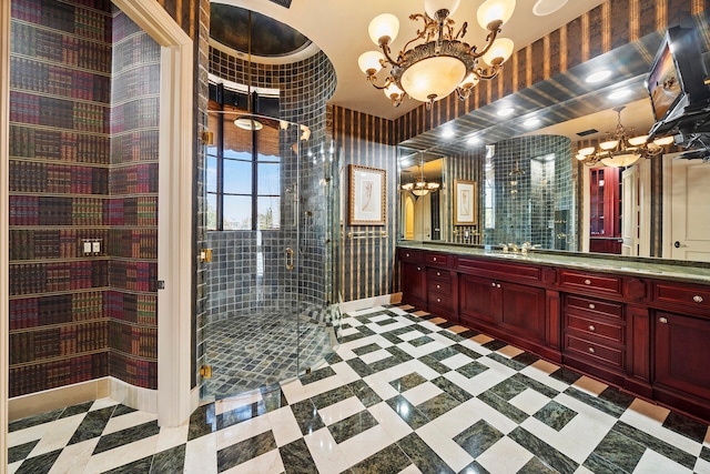 bathroom featuring vanity, a shower with door, and a chandelier