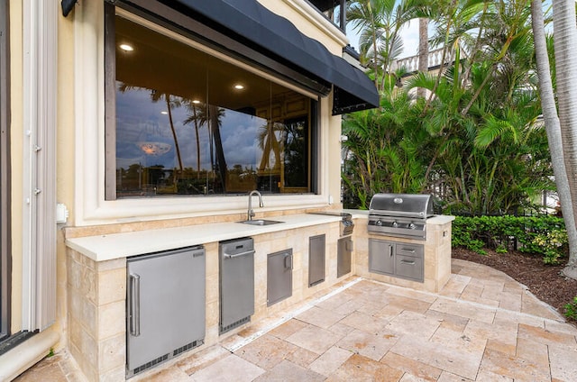 view of patio / terrace featuring grilling area, sink, and an outdoor kitchen