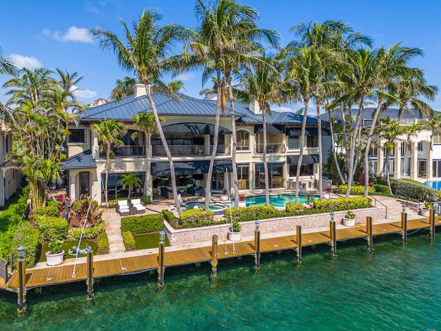 rear view of house featuring a balcony, a patio, and a water view