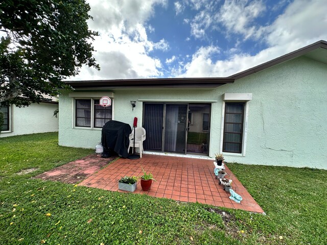 rear view of property with a lawn and a patio area