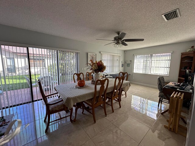 tiled dining room featuring ceiling fan and a textured ceiling