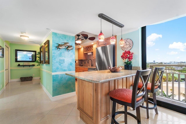 kitchen with tasteful backsplash, stainless steel fridge, light tile floors, and pendant lighting