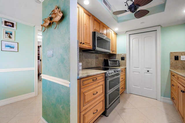 kitchen featuring ceiling fan, tasteful backsplash, a raised ceiling, light tile floors, and appliances with stainless steel finishes