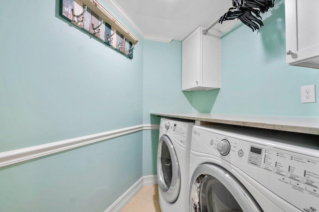 laundry area with cabinets, crown molding, light tile floors, and washing machine and clothes dryer