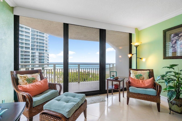 sitting room with floor to ceiling windows, tile flooring, a water view, and a textured ceiling