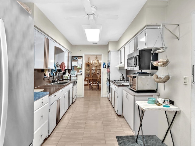 kitchen with white cabinetry, appliances with stainless steel finishes, sink, light tile flooring, and ceiling fan