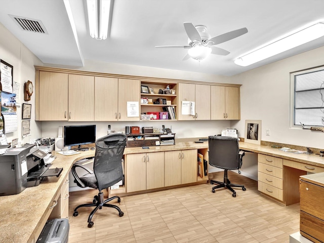 office featuring built in desk, ceiling fan, and light tile floors