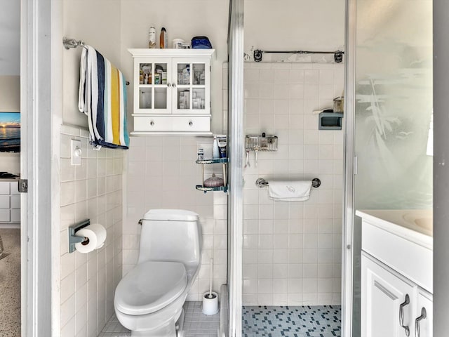 bathroom featuring tile walls, toilet, tile floors, an enclosed shower, and vanity