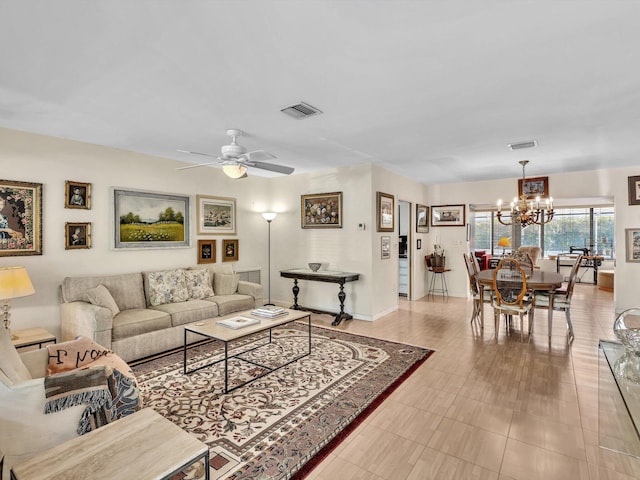 tiled living room featuring ceiling fan with notable chandelier