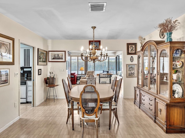 tiled dining room with an inviting chandelier