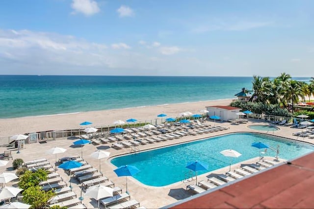 view of pool with a view of the beach, a patio, and a water view