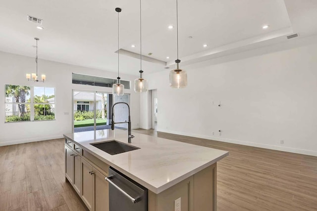 kitchen with sink, decorative light fixtures, dishwasher, light stone countertops, and a kitchen island with sink