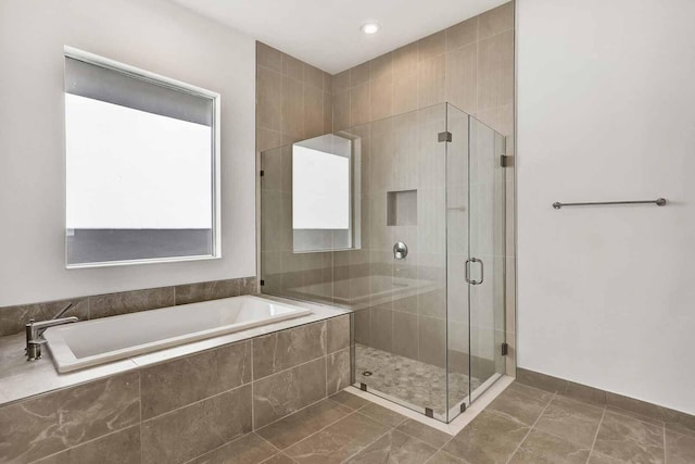 bathroom with a shower stall, tile patterned floors, and a bath