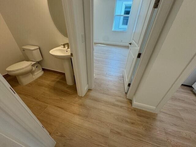 bathroom featuring toilet and wood-type flooring